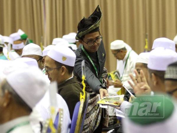 Petugas Muktamar Dewan Ulamak Pas mengedarkan risalah kepada hadirin yang hadir. FOTO SINAR HARIAN /ASRIL ASWANDI SHUKOR.