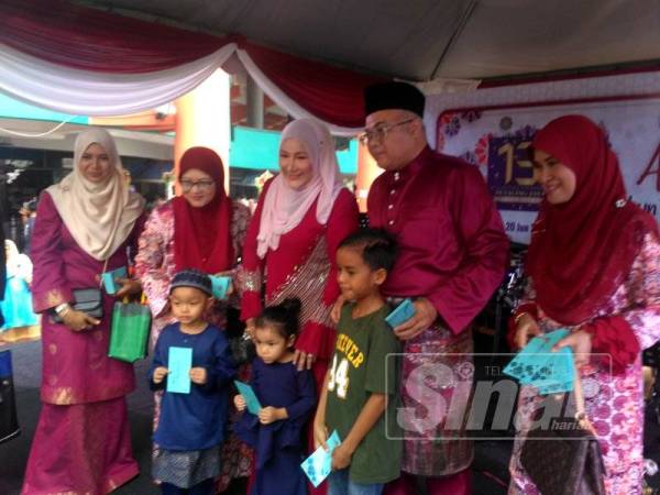 Sayuthi (dua dari kanan) merakamkan gambar kenangan selepas menyerahkan sumbangan duit raya kepada kanak-kanak yang hadir ke majlis tersebut.