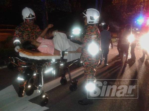 Anggota bomba membantu mengeluarkan isteri mangsa dari kenderaan sebelum dihantar ke Hospital Melaka.