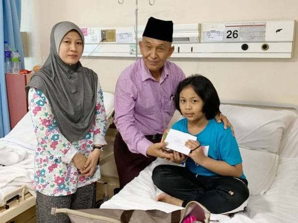 Tosrin (tengah) menyampaikan sumbangan kepada Ananurzawanah sambil diperhatikan Masni Salawati (kiri).