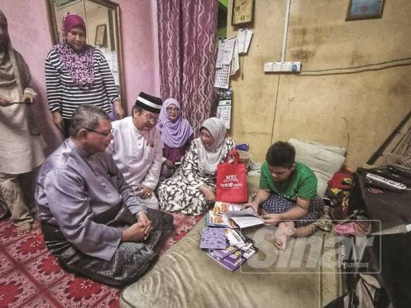  Saifudin (kiri) dan Mohd Anuar ketika melawat Muhammad Adam di rumahnya, kelmarin.