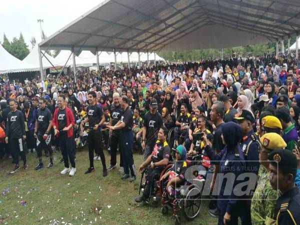 Syed Saddiq ( barisan depan, tengah) turut bersama peserta FitMalaysia melakukan senam aerobik antara aktiviti sempena perasmian program FitMalaysia di Daratan Batu Burok, di sini hari ini.