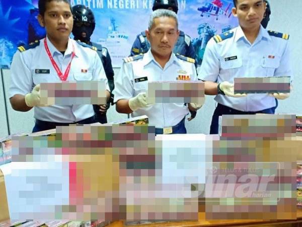 Ismail (tengah) menunjukkan rokok putih yang dirampas APMM semalam.