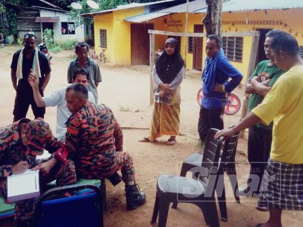 Anggota bomba sedang mendapatkan maklumat daripada penduduk.