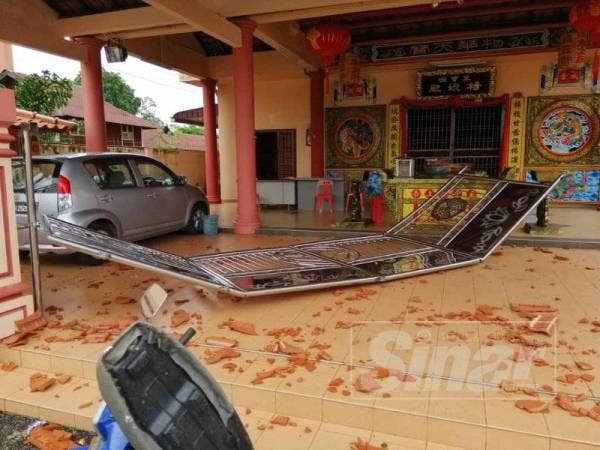 Pagar di sebuah tokong terbang gara-gara angin ribut pagi tadi.