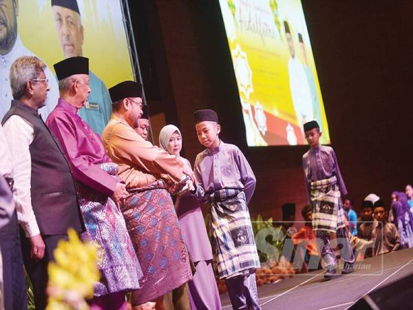 Mujahid (dua dari kiri) dan Syed Hussien (kiri) menyampaikan sumbangan hari raya kepada anak yatim dan asnaf pada majlis sambutan Aidilfitri MAIWP di Kuala Lumpur, semalam.- FOTO: SHARIFUDDIN ABDUL RAHIM 