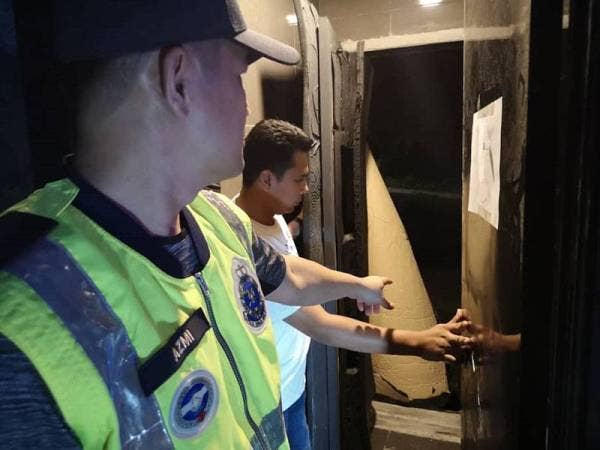 Azmi menunjukkan bilik rahsia yang dijadikan tempat GRO bersembunyi.- Foto Polis Selangor