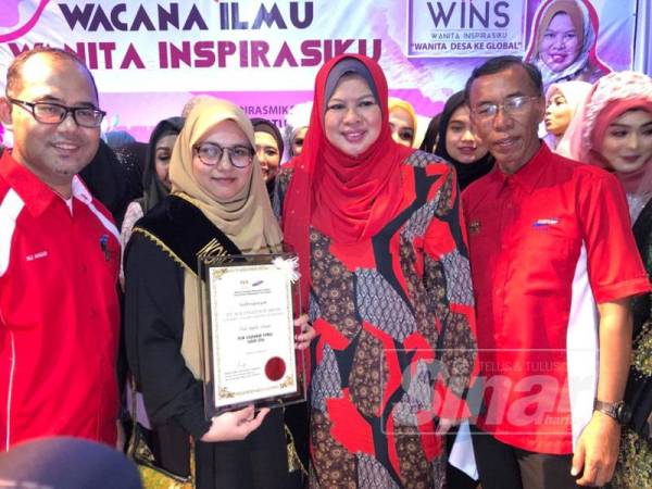 Rina (dua dari kanan) menyampaikan anugerah kepada Ikon Usahawan, Siti Nor Shazleen Maidin di atas pencapaiannya menghasilkan dan mengeksport telekung sehingga ke Arab Saudi.
