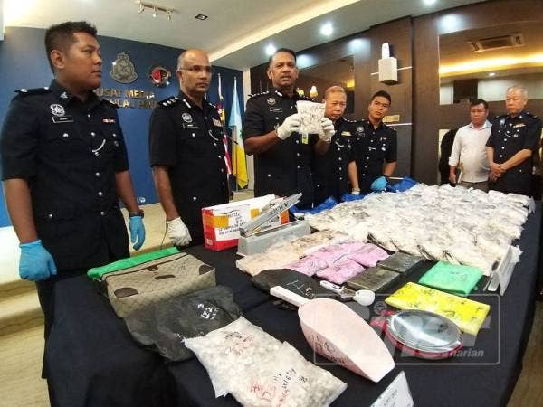 Narenasagaran (tengah) menunjukkan dadah heroin yang dirampas daripada suspek.