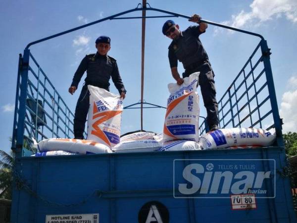 Anggota penguat kuasa memeriksa lori berisi baja yang siap dipek semula sebelum dipasarkan.