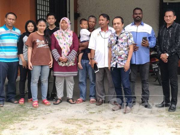 Roslan (empat, kanan), bersama kedua-dua keluarga, di inap desa berkenaan.