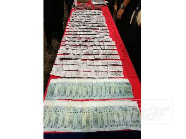 Antara rampasan wang tunai dan dadah yang dirampas dalam serbuan di Kampung Baru, Kuala Lumpur, Khamis lalu.