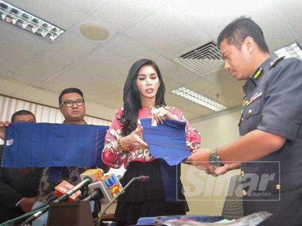 Sajat menunjukkan produk bengkungnya yang didakwa diciplak kepada Azeem (kanan) di Pejabat KPDNHEP Kuala Lumpur, hari ini. - FOTO SHARIFUDIN ABDUL RAHIM