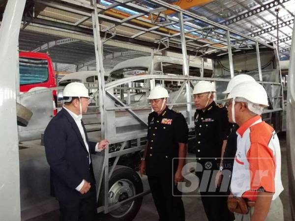 Shaharuddin (dua dari kiri) meninjau persekitaran kilang pembinaan bas di Pelabuhan Klang, hari ini.