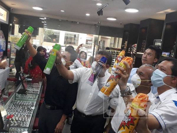 Mohd Zohdi (kanan) turut sama menyertai aktiviti semburan racun serangga di deretan kedai di hadapan pusat beli-belah City Plaza.