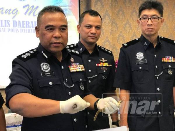 Osman (kiri) memegang palam pencucuh yang digunakan suspek untuk memecah cermin kereta sebelum melarikan beg tangan mangsa.