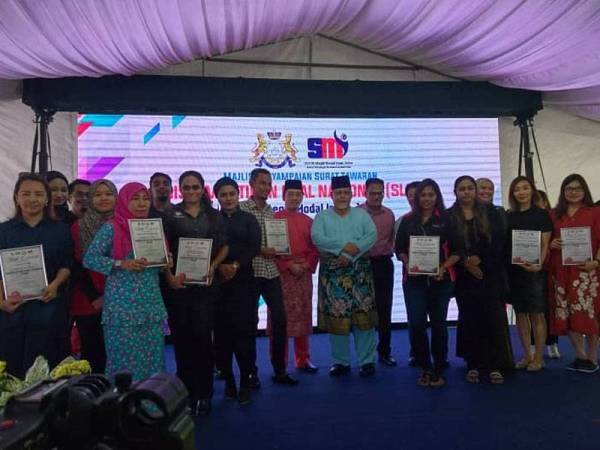 Aminolhuda Hassan (tengah) bergambar bersama sembilan pengusaha yang terlibat dengan Program Sistem Latihan Dual Nasional anjuran Unit Strategik Modal Insan Johor dalam majlis penyampaian surat tawaran program berkenaan di Iskandar Puteri, di sini hari ini.