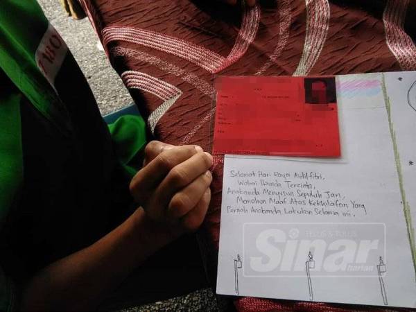 Seorang penghuni menunjukkan kad hari raya yang dibuatnya untuk diberikan kepada keluarganya pada majlis itu.