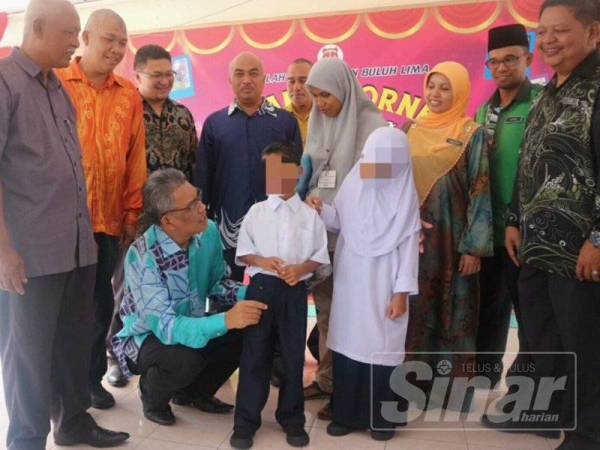 Ismail (duduk) bertanya sesuatu kepada Muhammad Noor Akif sambil diperhatikan kakaknya, Nur Athirah Khairina.