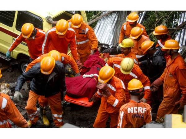 Pekerja keselamatan membawa keluar mayat dari lokasi runtuhan di bandar Pune, India. - Foto AFP