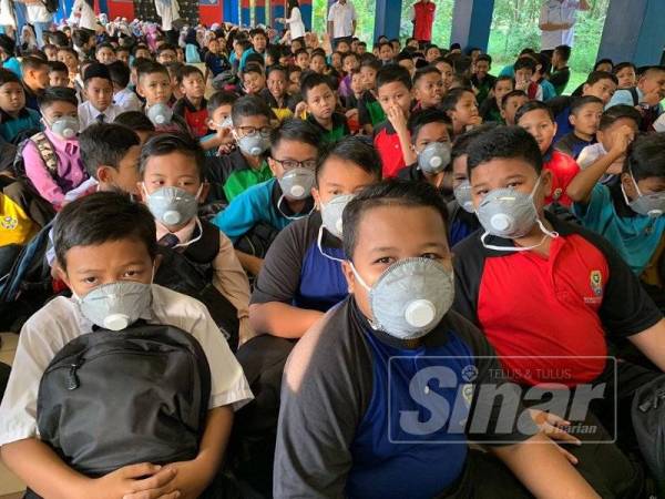 Murid SK Pasir Gudang 4 memakai penutup mulut dan hidung.