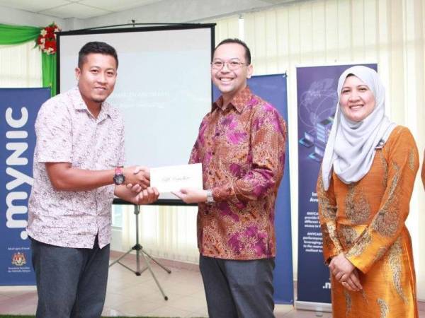 Hasnul Fadhly menyampaikan anugerah kepada Muhammad Ibtisyam (kiri) pada majlis itu.