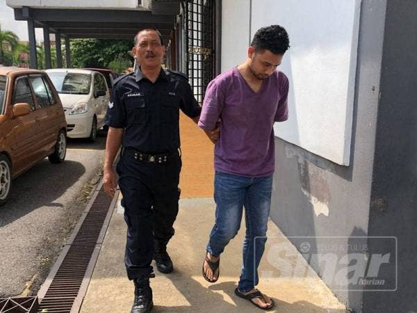 Tertuduh (kanan) dibawa keluar dari Mahkamah Sesyen selepas mengaku salah merompak kedai serbaneka di Pengkalan Chepa.