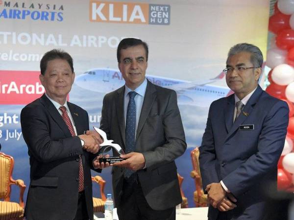 Datuk Mohammadin Ketapi (kiri) menerima cenderahati daripada Ketua Pegawai Eksekutif Kumpulan Air Arabia Adel Abdullah (dua, kanan) pada majlis menyambut ketibaan pertama pesawat Air Arabia di Lapangan Terbang Antarabangsa Kuala Lumpur (KLIA) hari ini. Foto: Bernama