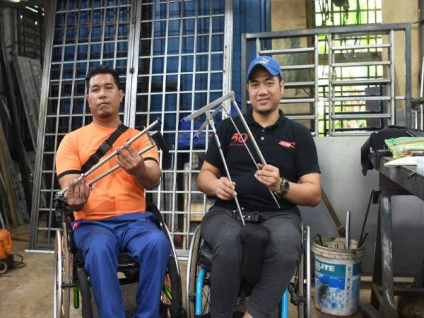 MOHD AFIQ (kanan) dan Hairul Anuar membuktikan kecatatan bukan penghalang untuk mereka berbakti kepada golongan senasib dengan mencipta HDC bagi membantu OKU memandu kereta. -Gambar Bernama
