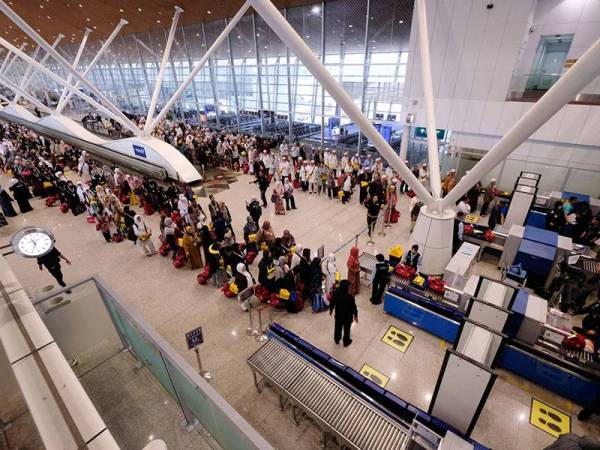 Para jemaah haji pada penerbangan kedua melakukan pemeriksaan keselamatan sebelum berangkat menunaikan haji 1440H di Lapangan Terbang Antarabangsa Kuala Lumpur (KLIA) hari ini. - Foto BERNAMA
