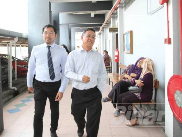 Chang Kok Kheong (kanan) keluar dari Mahkamah Majistret Ipoh selepas didakwa atas tiga pertuduhan memperdaya bagi tujuan pembayaran deposit untuk projek kondominium pelajar yang tidak wujud, tujuh tahun lalu.