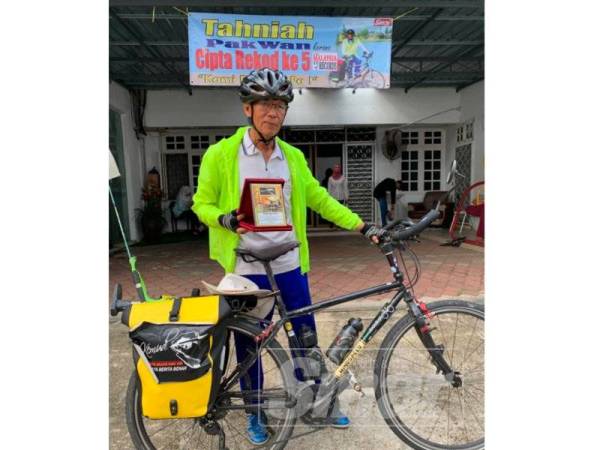 Pak Wan memegang plag hadiah penghargaan dan tahniah daripada pihak Kemudi.