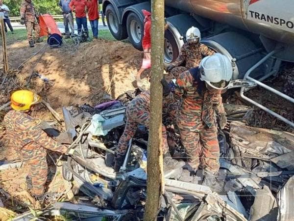 Anggota bomba mengeluarkan mayat mangsa yang tersepit dalam kemalangan maut di KM127 Jalan Kuantan- Segamat di sini awal pagi tadi.