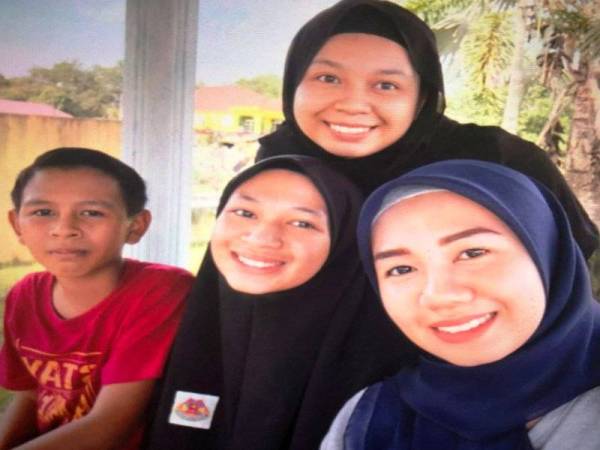 Wan Muhammed Adam (kiri) bersama kakaknya ketika menghantar Wan Nurfazleen Amirah melanjutkan pelajaran ke universiti swasta di Petaling Jaya, bulan lalu.