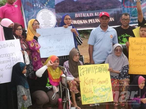 Halimah (duduk kiri) dan Siti Ajar (kanan) bersama dengan penduduk lain dalam himpunan aman hari ini.