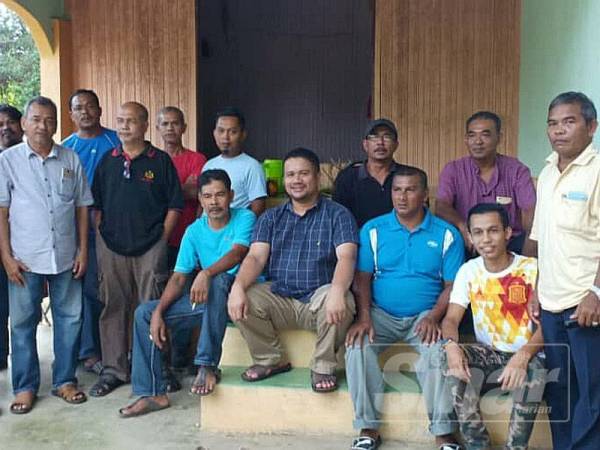 Azran (duduk, depan dua kiri) bersama sebahagian penduduk Kampung Jedok dalam siri ziarahnya di kampung berkenaan di sini hari ini.