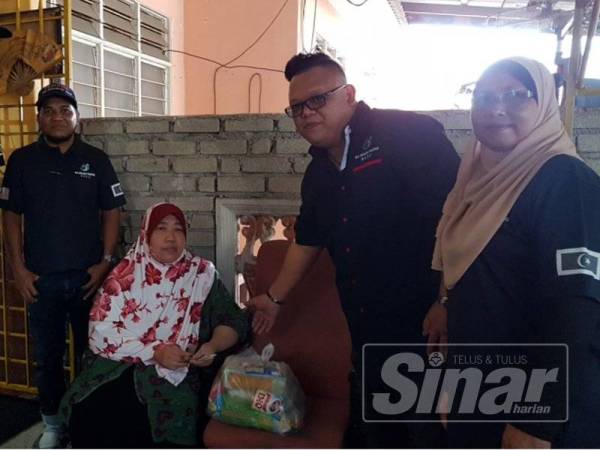 Jack (dua dari kanan) menyampaikan bantuan kepada pesakit kanser, Anita Abdul Ghani, 52, di Taman Banggol Indah.