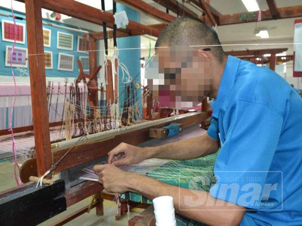 ‘Panjang’ sedang melakukan menenun kain yang ditempah.