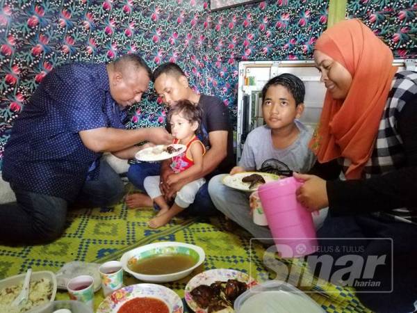 Mohd Hamidi (kiri) menyuap makanan ke Noraziana Khatijah sambil diperhatikan oleh kedua ibu bapanya.