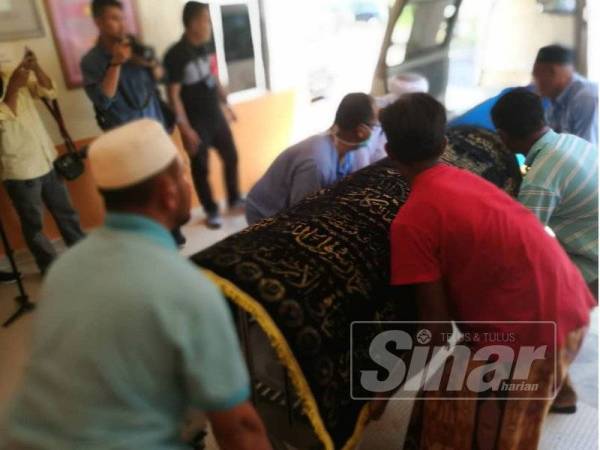 Jenazah salah seorang mangsa yang dibawa keluar dari bilik mayat HTM selepas selesai urusan bedah siasat.