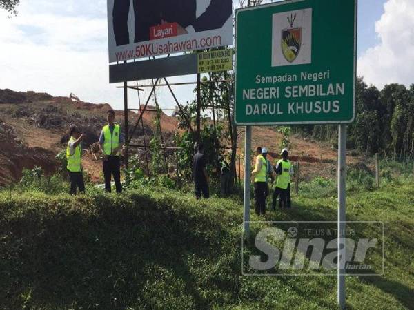 Teo Kok Seong semasa meninjau kerja-kerja merobohkan papan iklan haram di Lebuh Raya Plus Arah Selatan berdekatan Bukit Mahkota, Nilai, hari ini.