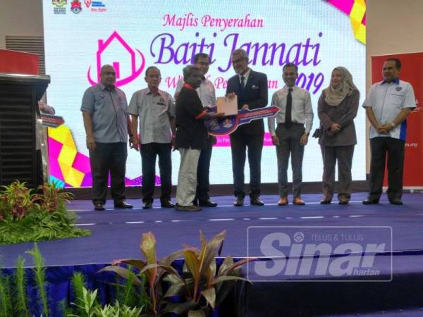 Khalid menyerahkan insiatif PBJ Wilayah Persekutuan kepada salah seorang penerima asnaf sewaktu program berlangsung di Kompleks Sukan Pantai Eco Park.