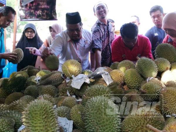 Fauzi (empat dari kiri) melihat buah durian yang dijual di Pasar Tani Padang Hiliran di sini.