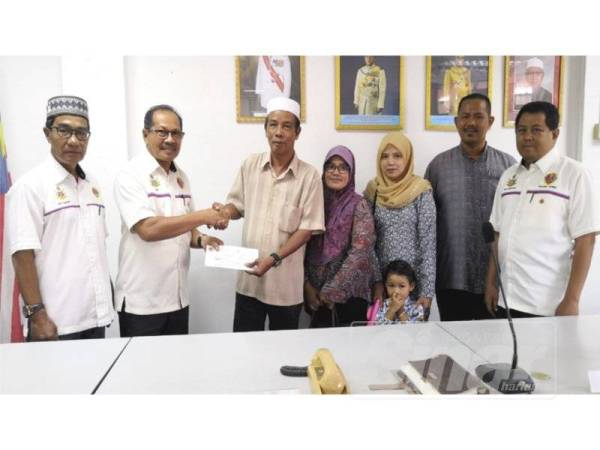 Ab Aziz (dua kiri) menyampaikan sumbangan cek bernilai RM1,000 kepada Ab Rahim (tiga kiri).