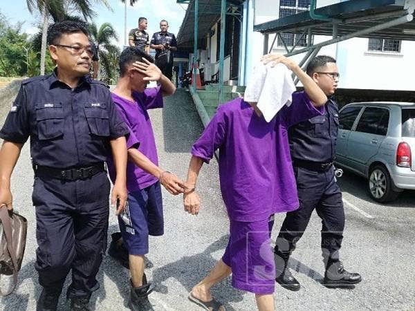 Tertuduh menutup mukanya dengan tuala sebaik selesai prosiding di mahkamah di sini hari ini.