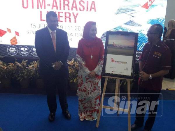 Raja Zarith Sofiah, Tony (kiri) dan Ismail (kanan) menyempurnakan pelancaran UTM-AirAsia Livery semalam.