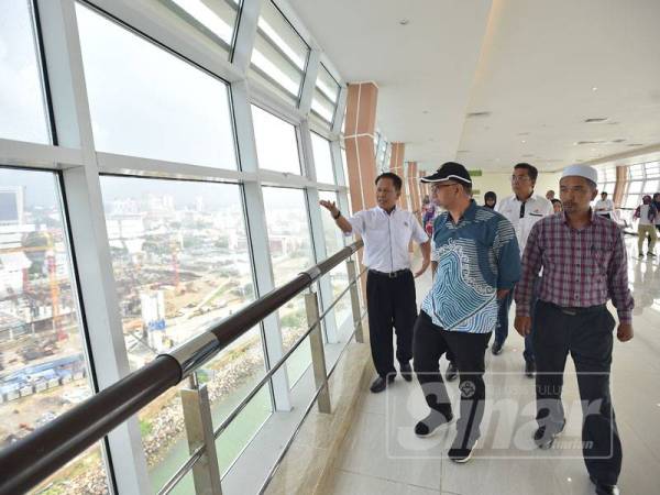 Timbalan Menteri Pelancongan, Seni dan Budaya, Muhammad Bakhtiar Wan Chik (tengah) diberi penerangan mengenai jambatan angkat ketika melakukan lawatan di menara bangunan ikonik itu di Kuala Terengganu, semalam.