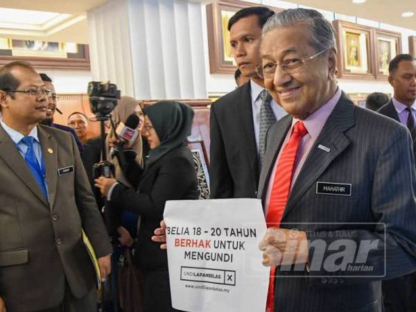Perdana Menteri, Tun Dr Mahathir Mohamed memegang poster 'Belia18-20 tahun berhak untuk mengundi' di Parlimen hari ini. - Foto SHARIFUDIN ABDUL RAHIM