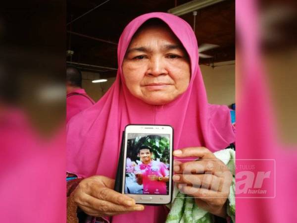 Ibu mangsa menunjukkan gambar anaknya yang terkorban dalam kemalangan.