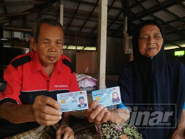 Idris dan isterinya menunjukkan kad pengenalan yang menunjukkan umur mereka pada tahun ini berusia 115 tahun dan 80 tahun.